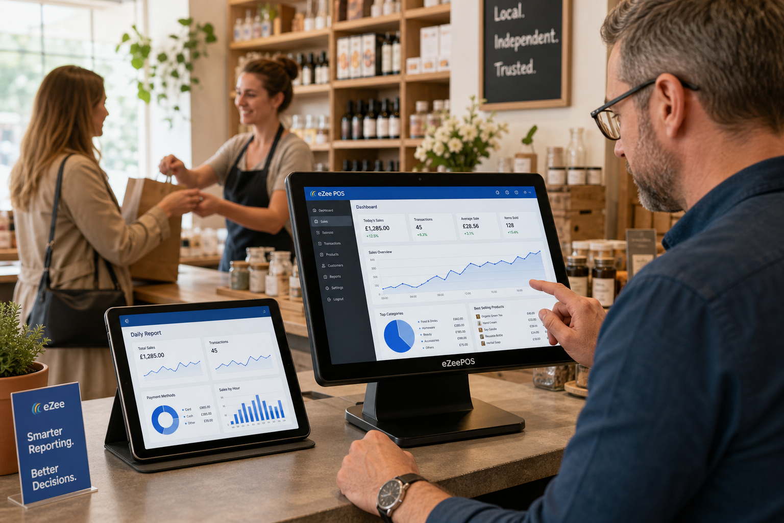How Better Reporting Helps Small Shops Make Smarter Day-to-Day Decisions - Photorealistic commercial photography of a modern independent UK retail shop counter with a business owner reviewing clear sales charts and dashboards on an eZeePOS-style touchscreen POS terminal, with a tablet beside it showing daily reporting graphs and simple trend lines, a friendly staff member in the background serving a customer, clean counter space, subtle blue brand accents on the screen interface and small signage, natural window light, shallow depth of field, warm professional atmosphere, realistic products on shelves behind the counter, premium but believable composition, focused on reporting technology helping a small shop make smarter trading decisions, suitable as a WordPress featured image.