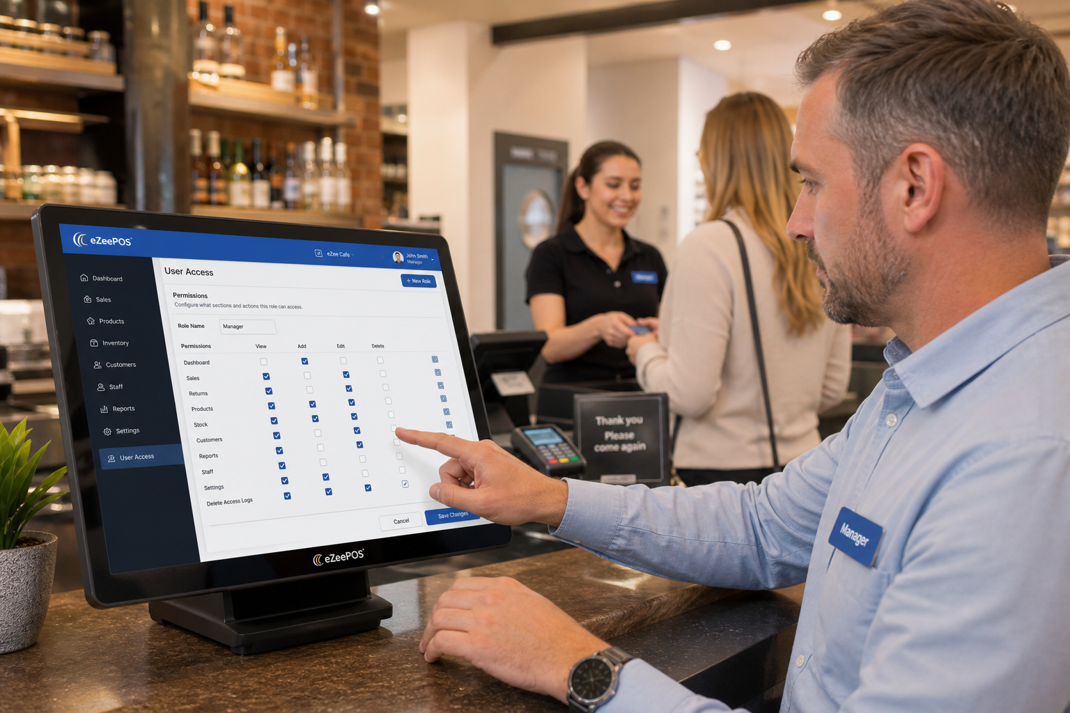 Why Staff Permissions Matter in a Growing Retail or Hospitality EPOS, photorealistic commercial photography style, a warm modern UK retail or hospitality counter scene showing a manager reviewing user access settings on an eZeePOS-style touchscreen POS terminal while a colleague serves a customer in the background, subtle blue brand accents on the screen interface and small staff name badges, clean counter area, realistic till environment, professional but approachable mood, shallow depth of field, natural lighting, premium yet realistic composition, the technology and permission control screen clearly visible, suitable as a WordPress featured image for a UK EPOS blog, no clutter, no abstract background, no cartoon style, no exaggerated futuristic elements